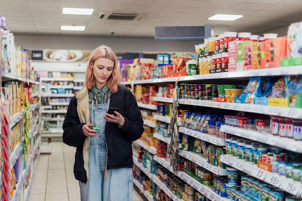 Supermarket aisle, close on hands and a phone