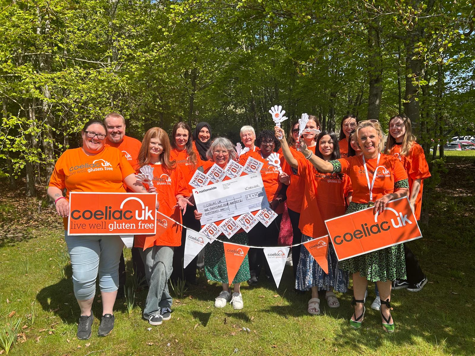 Coeliac UK team celebrating and holding cheque from Nationwide