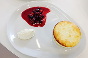 Lemon souffle with fruit compote and cream