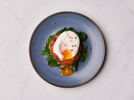 Sweet potato cake with wilted spinach a poached egg and chilli flakes