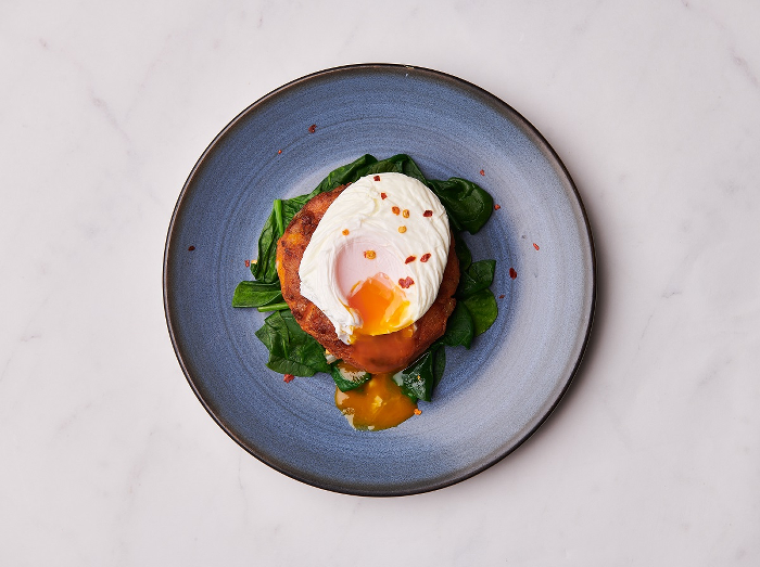 Sweet potato cake with wilted spinach a poached egg and chilli flakes 