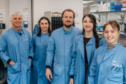 5 researchers in blue lab coats